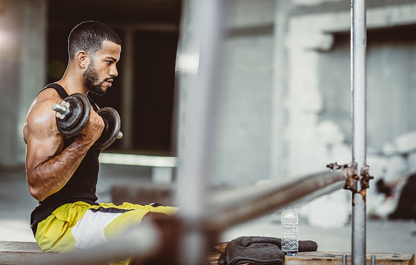 male doing seated dumbbell curls